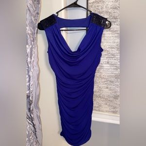 Tight blue dress with black rhinestones on the shoulders and an open back.